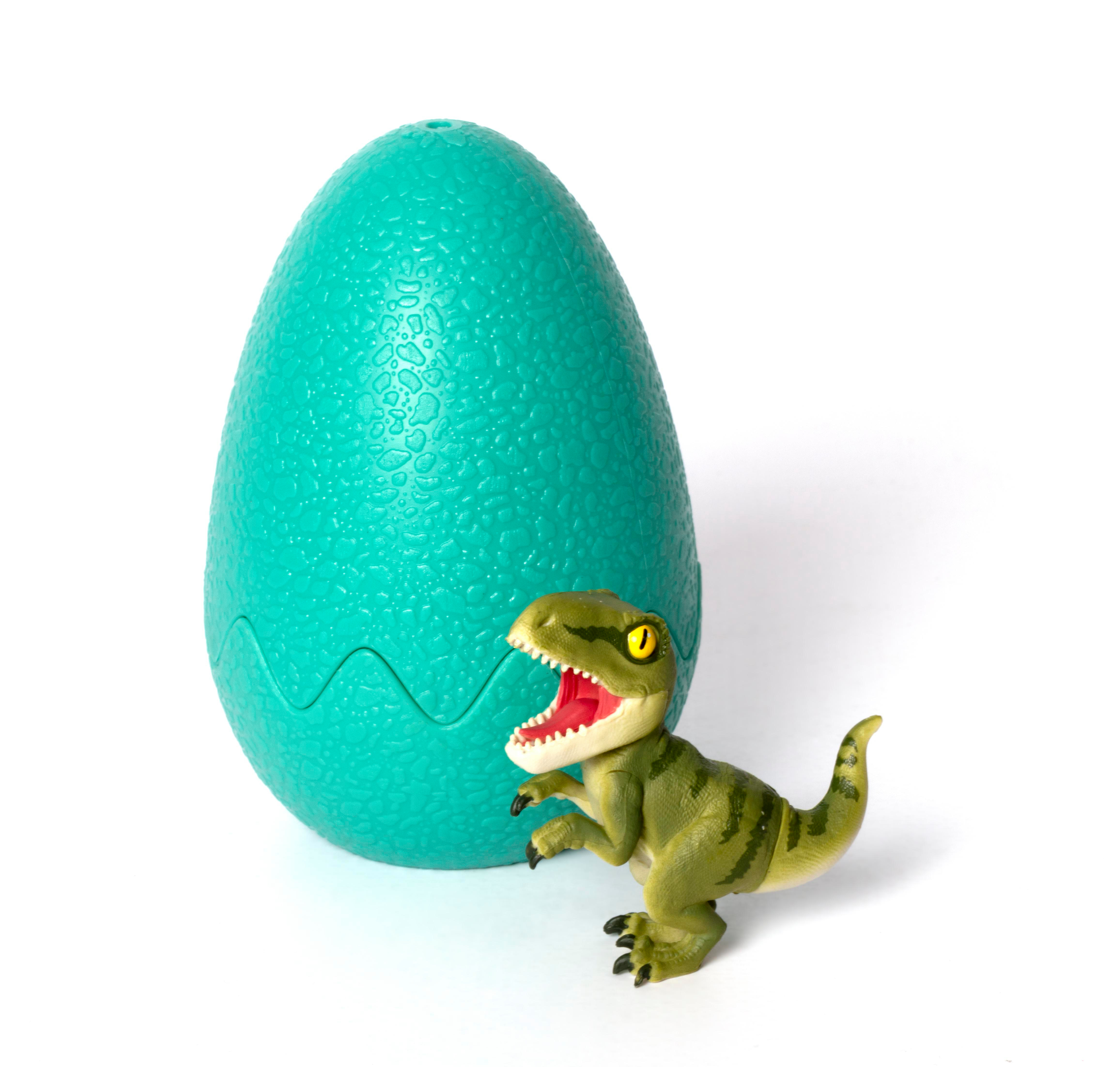 Dinosaurier-Spielzeug und grünes Ei. Weißer Hintergrund.