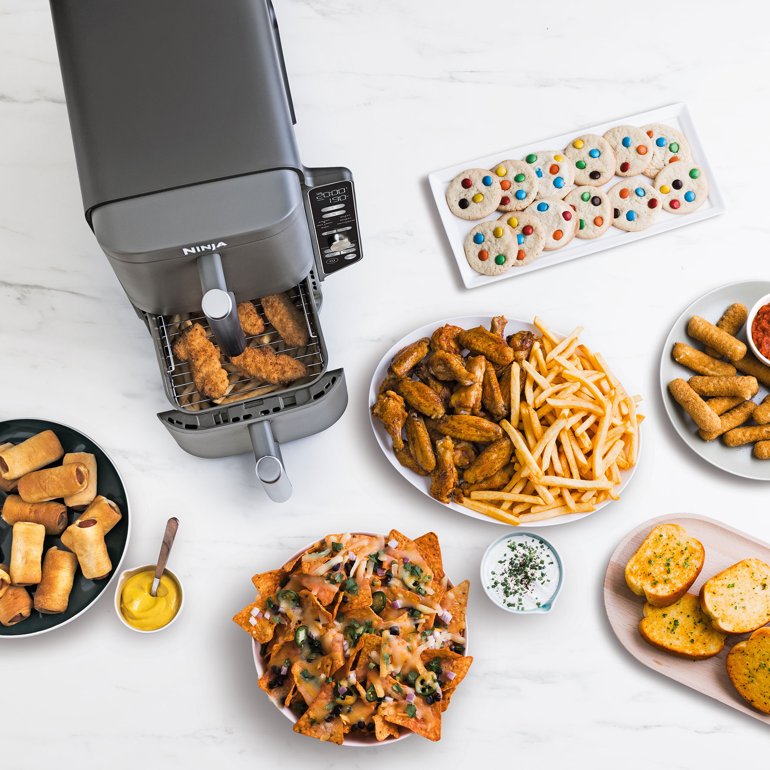 Food spread: Air fryer with food, cookies, fries, wings, nachos, mozzarella sticks, garlic bread.