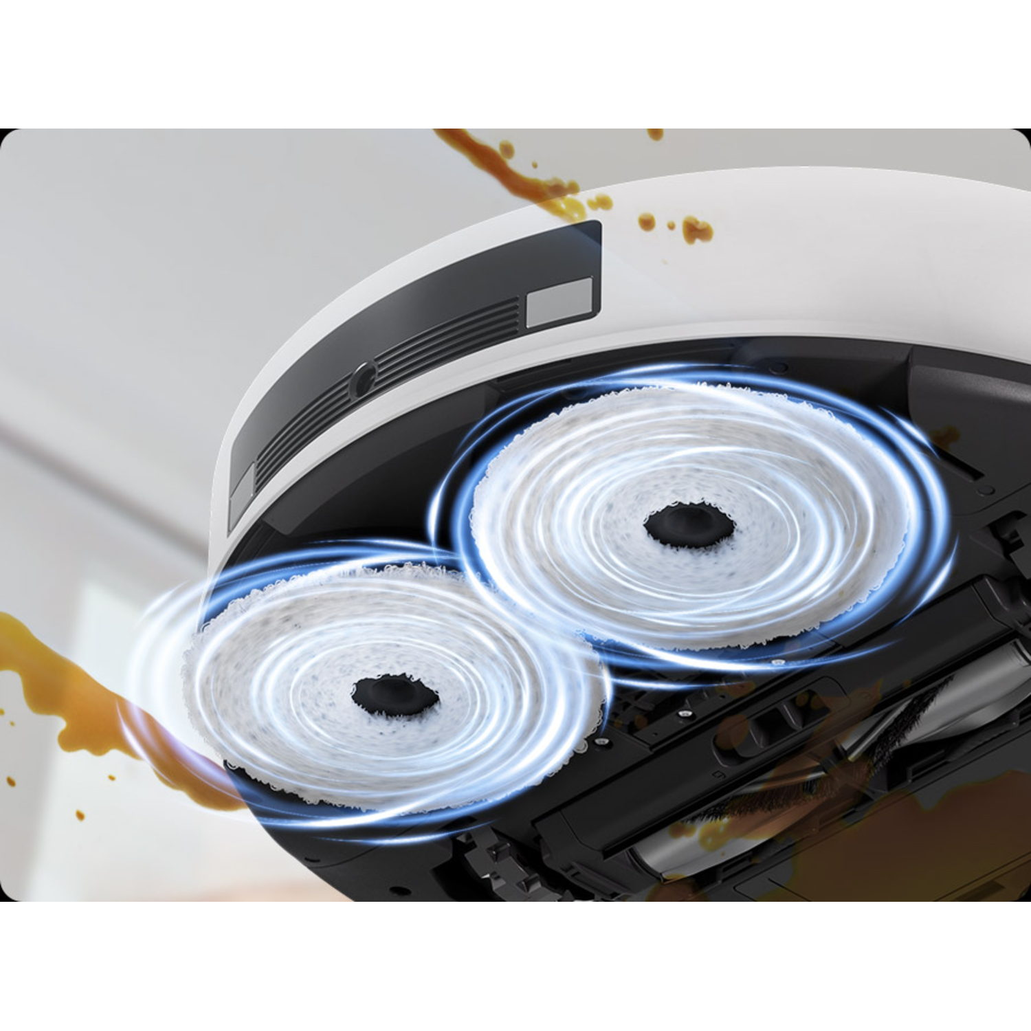 Robot vacuum's underside: two rotating brushes and brown liquid stains on a light surface.