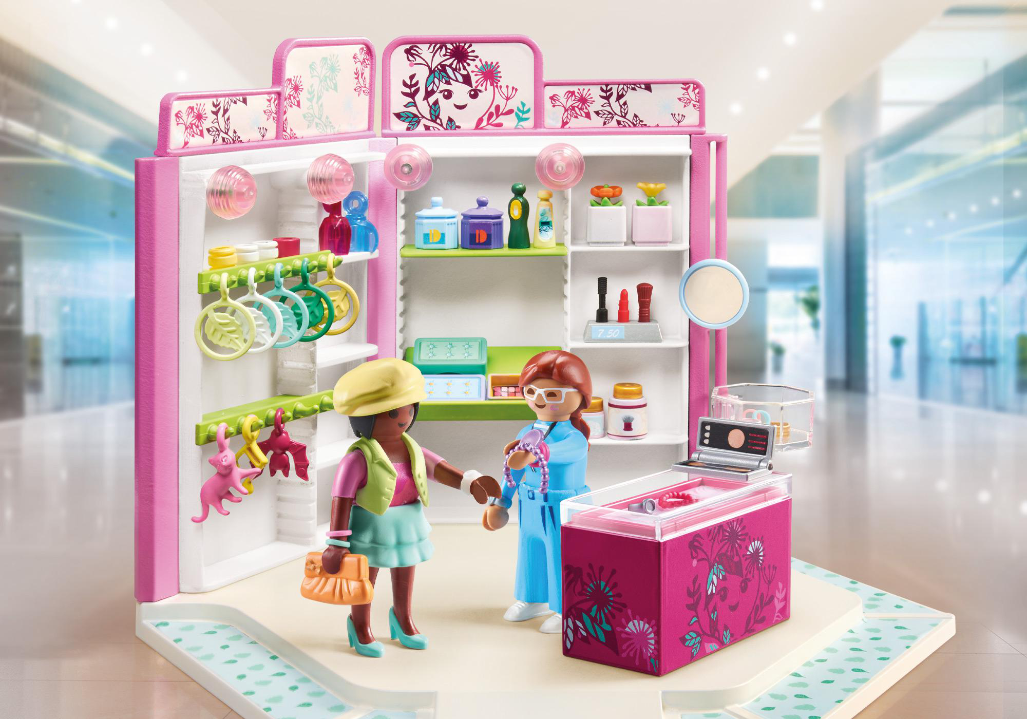 Playmobil Spielzeugladen-Szene. Zwei Figuren interagieren mit Laden-Displays und einer Kasse.
