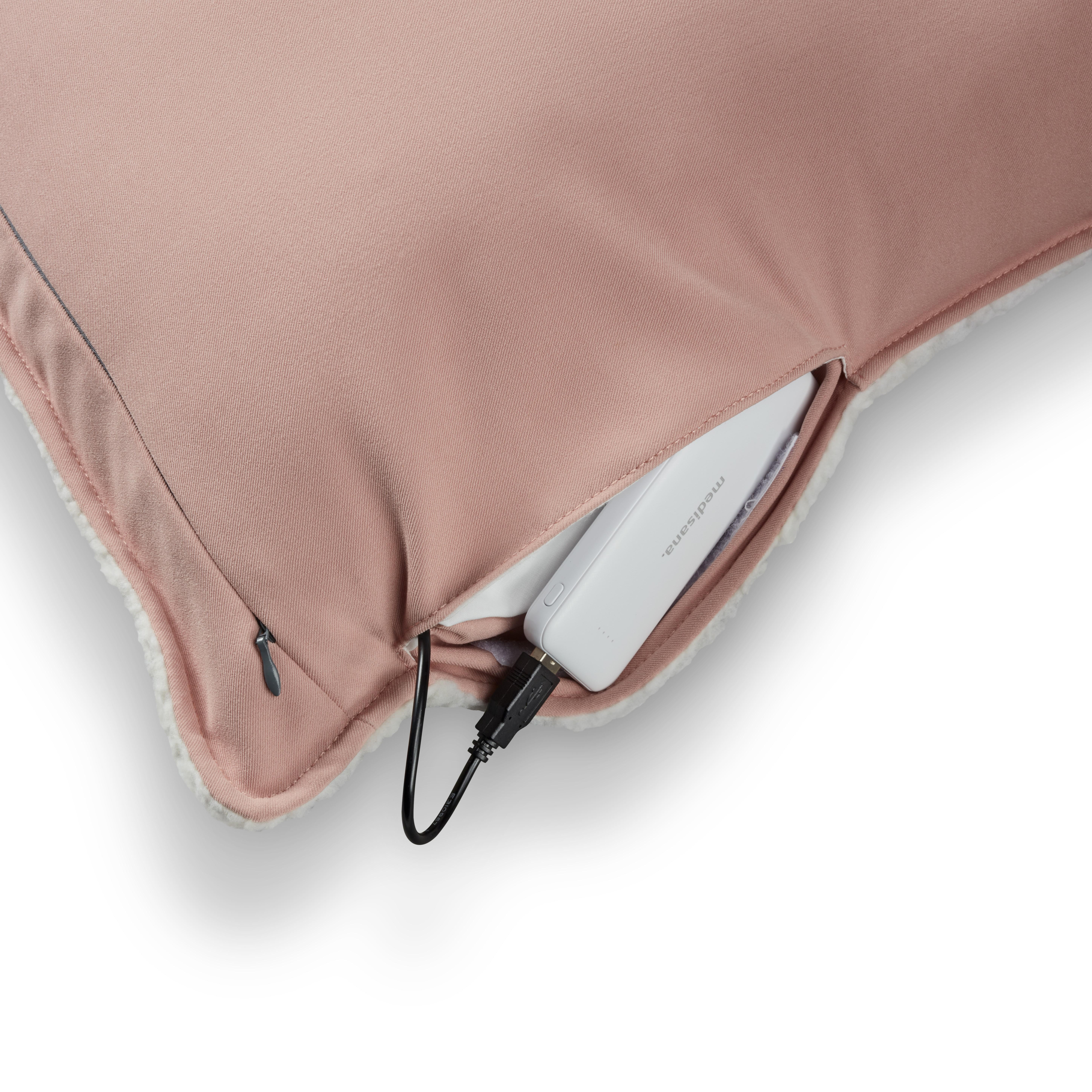 Ein rosa Kissen mit weißem, flauschigem Rand hat ein Ladekabel, das herausragt.