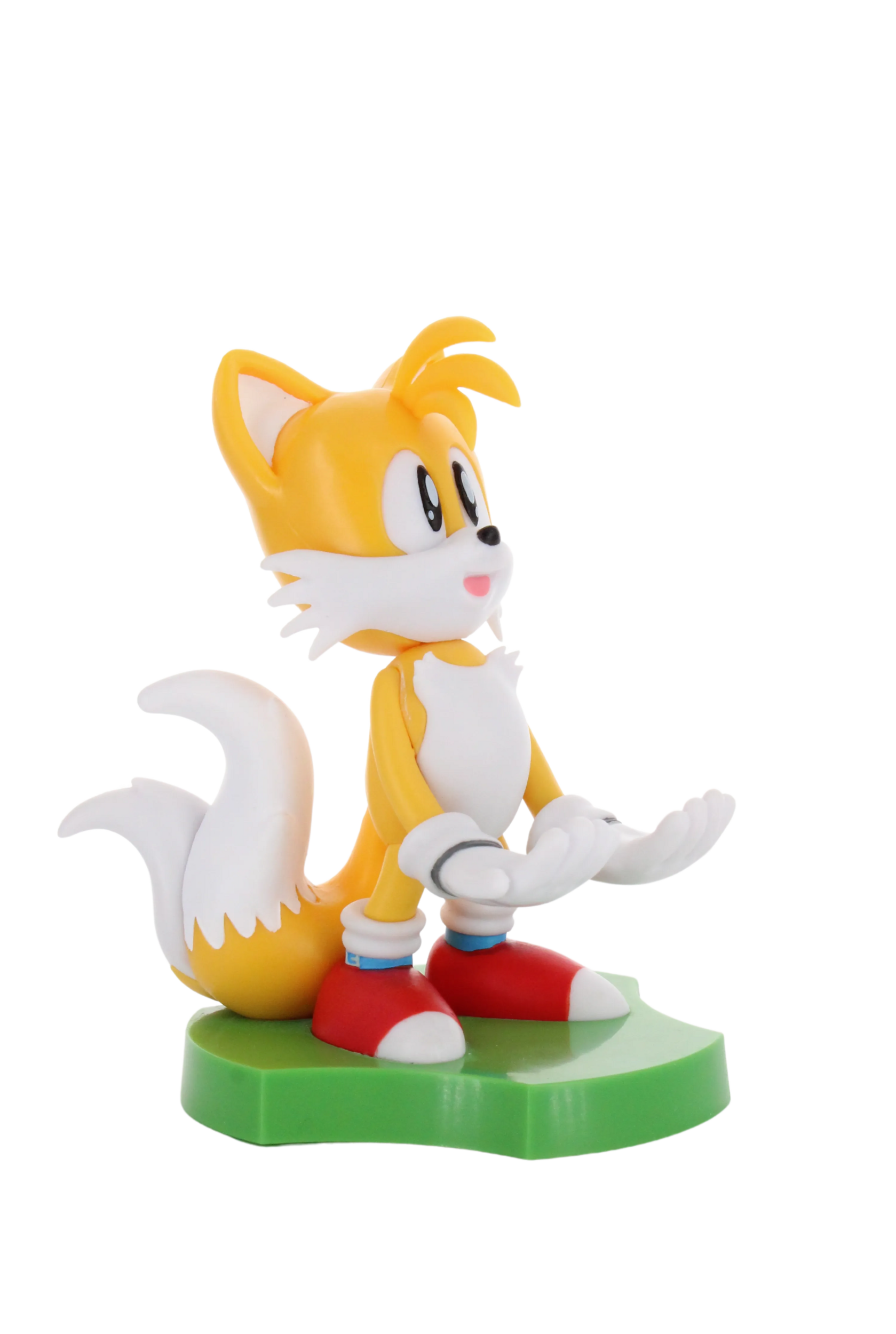 Tails, die Fuchsfigur, gelb und weiß, steht auf Grün.