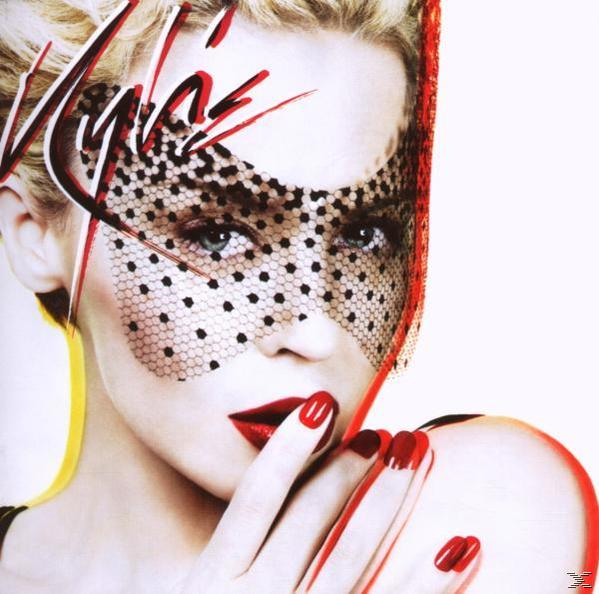 Gros plan sur le visage d'une femme avec des lèvres et des ongles rouges, portant un voile à pois.