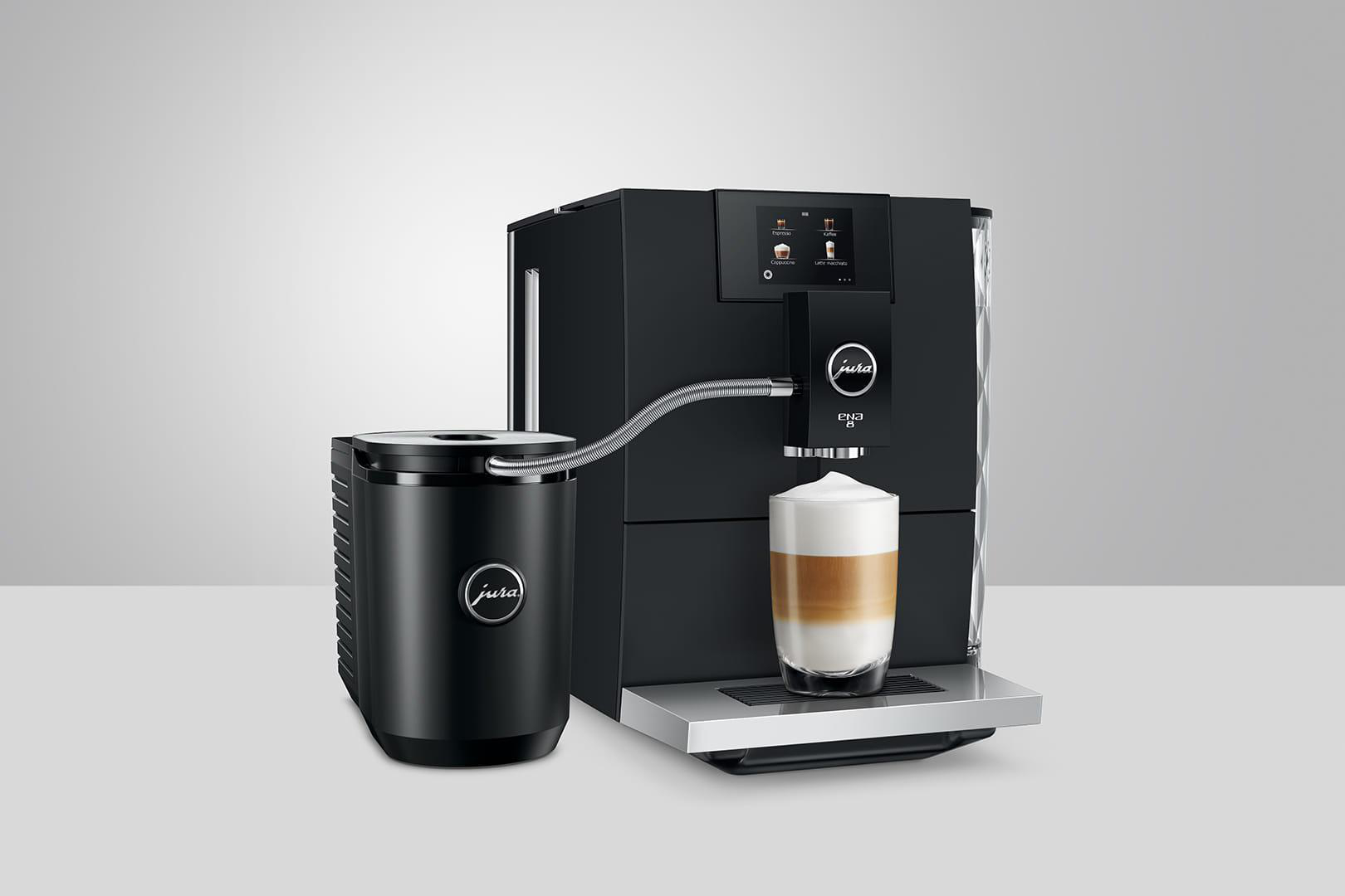 Eine schwarze Jura Kaffeemaschine mit Milchbehälter, die einen Latte mit geschichteter Milch zubereitet.