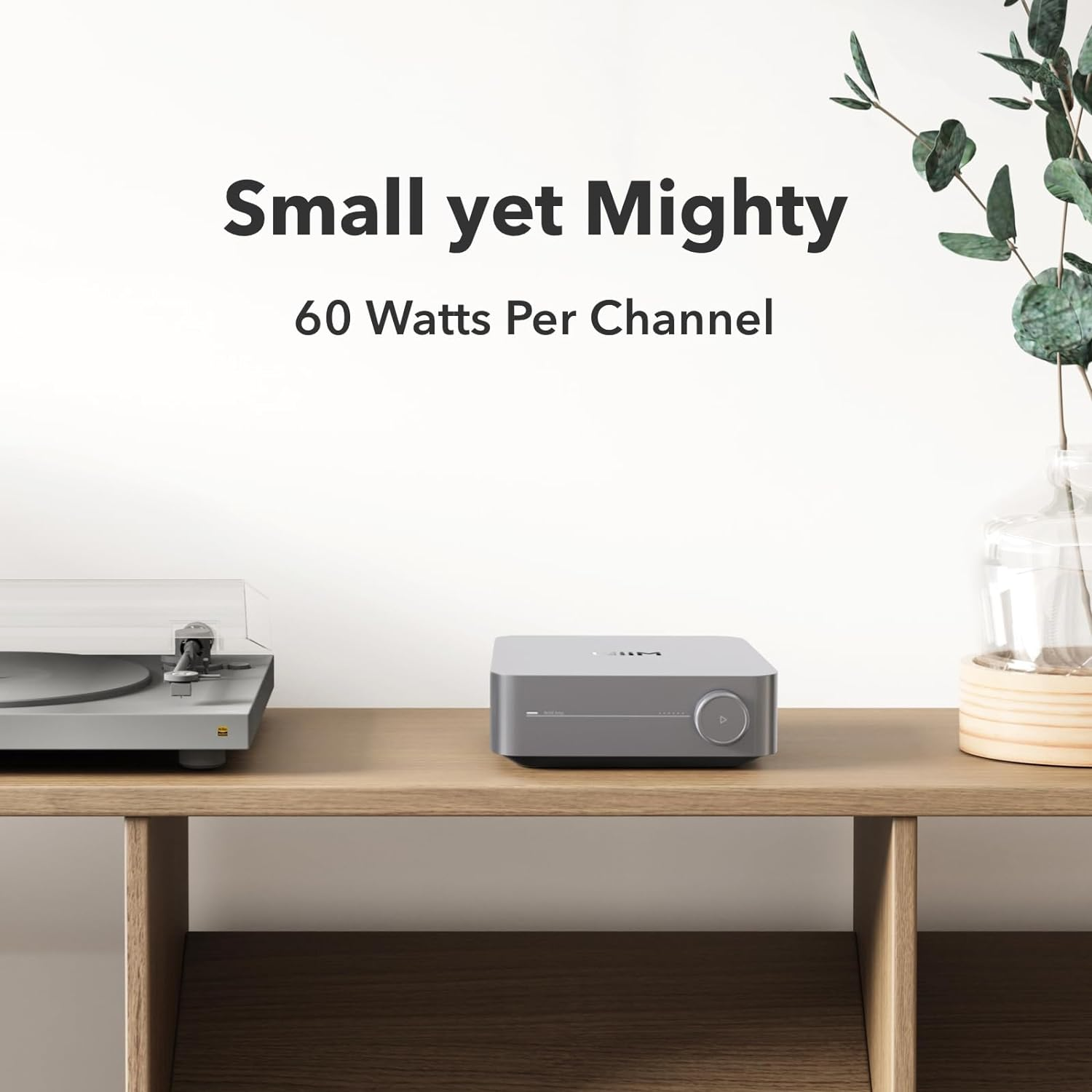 Un dispositivo audio grigio e un giradischi su una mensola di legno, con il testo "Small yet Mighty".