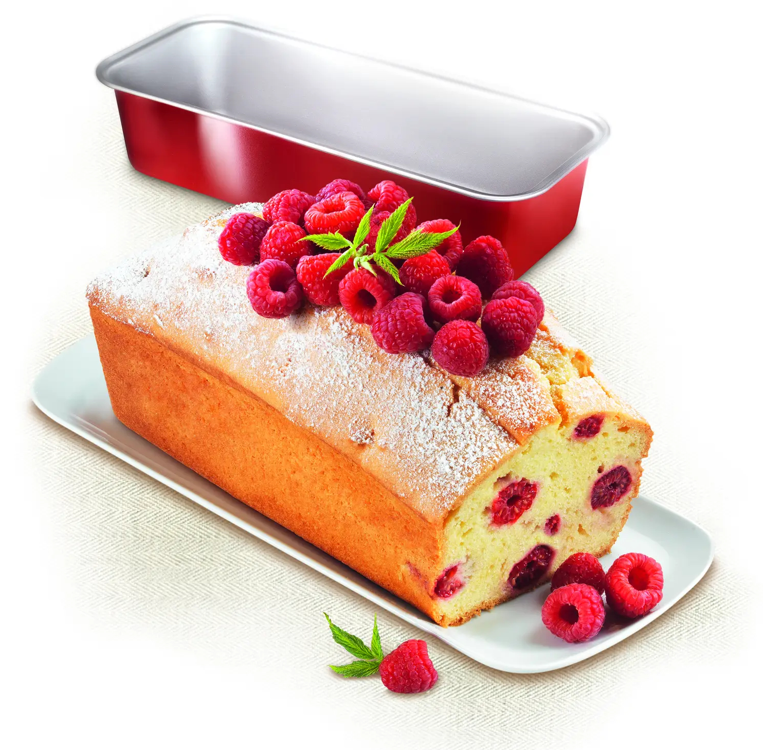 Ciasto malinowe na białym talerzu. Czerwona forma do pieczenia w tle.
