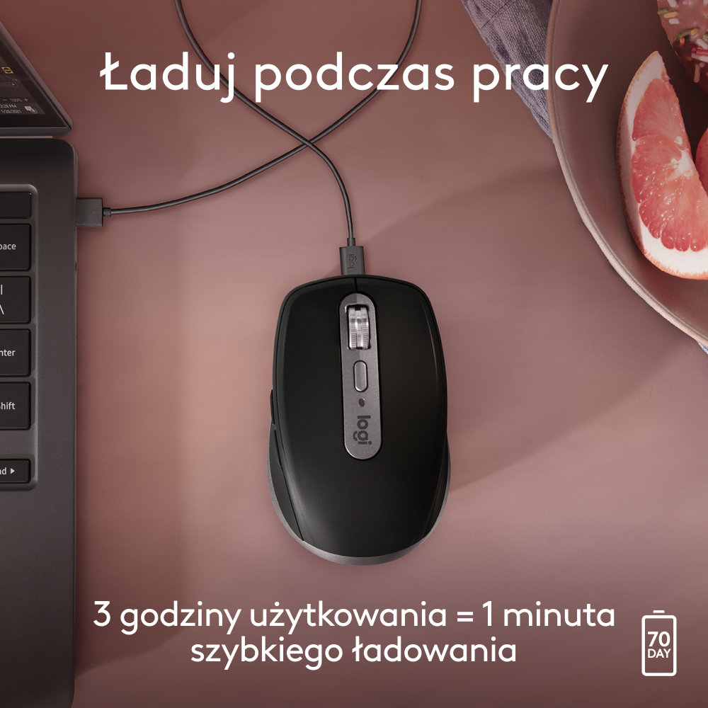 Czarna mysz na różowej powierzchni. Podłączony kabel ładujący. Tekst po polsku.
