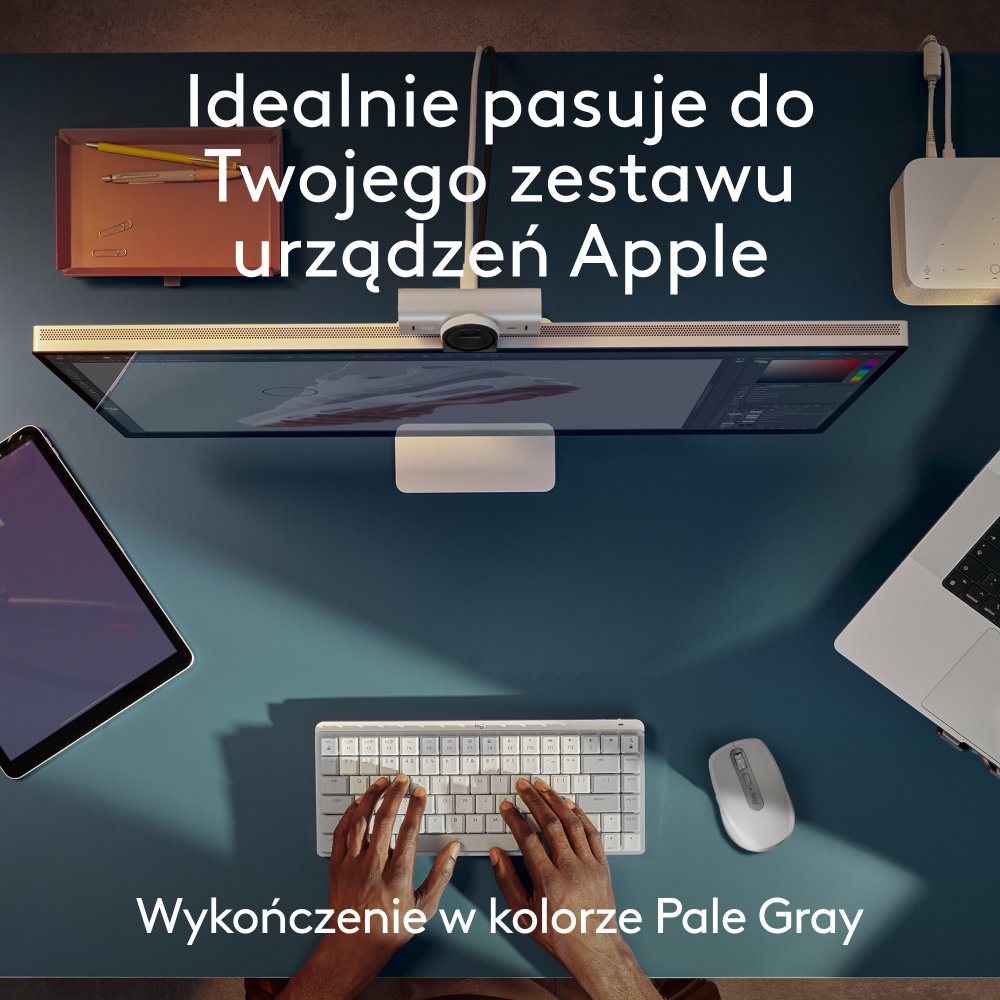 Widok z góry na biurko z monitorem, klawiaturą, myszą i tabletem. Schemat kolorów biały i niebieski.