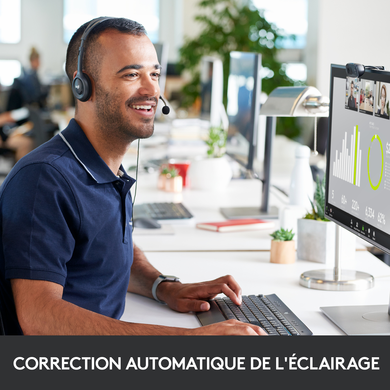 Homme portant un casque sur un bureau, avec un écran d'ordinateur affichant des graphiques.