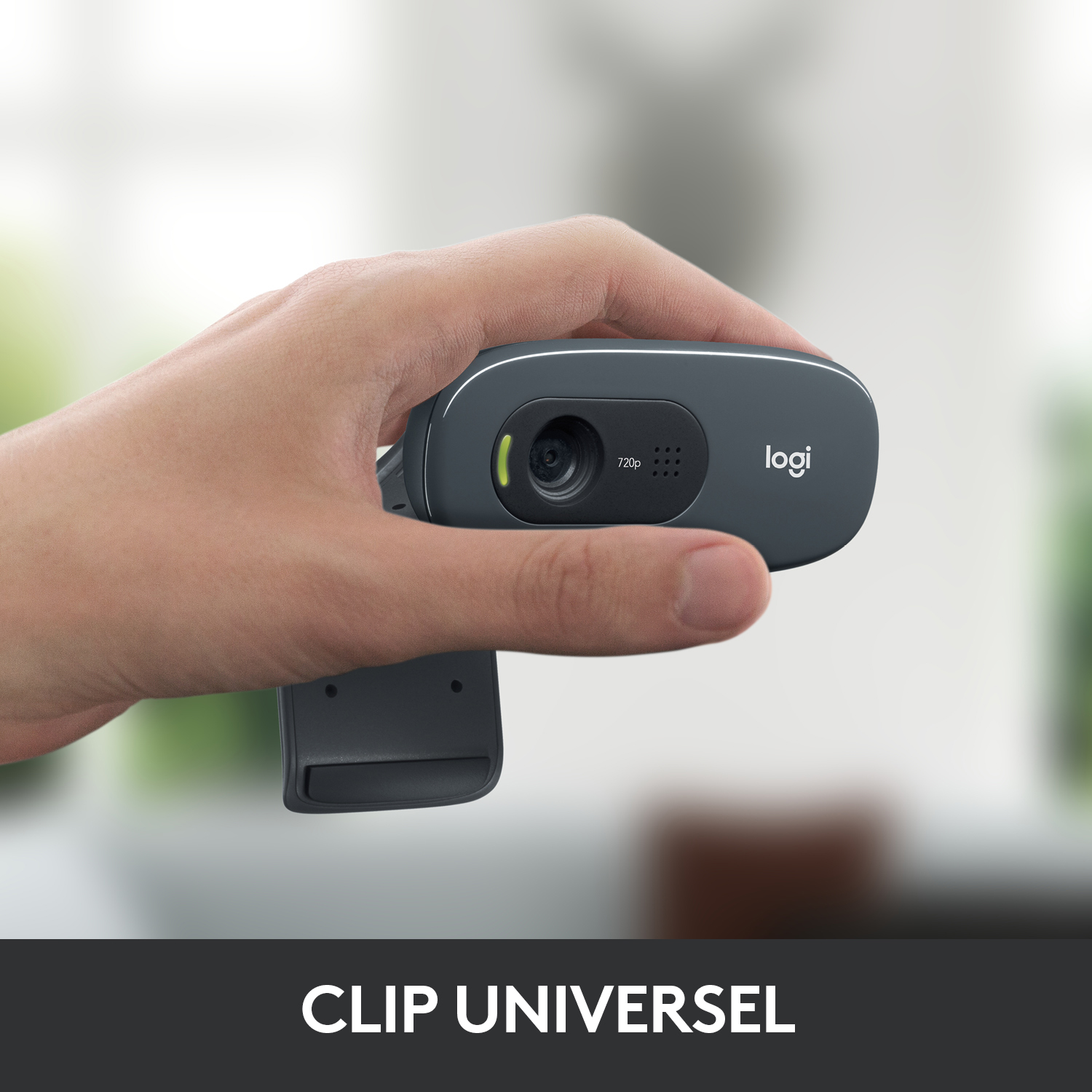 Une main tient une webcam gris foncé. Le mot 'logi' est visible. Une étiquette dit '720p'.