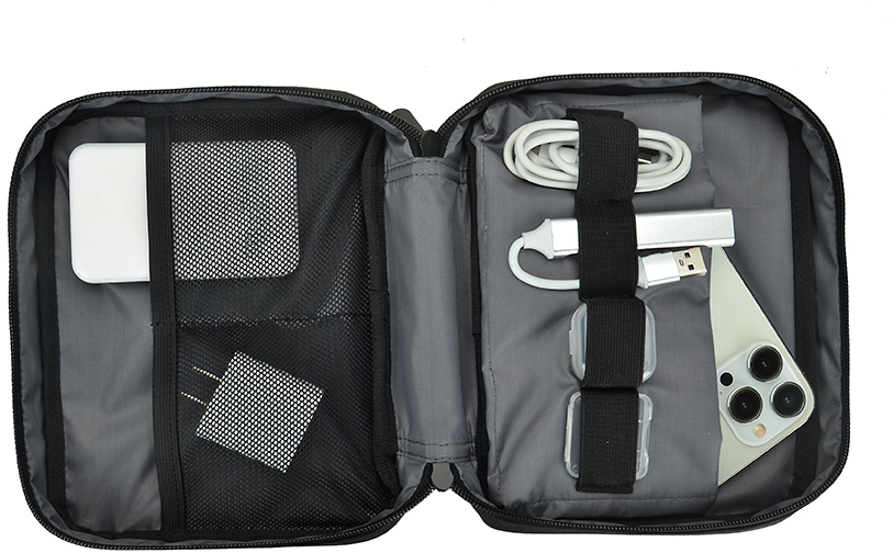 Offene, schwarze Tech-Reisetasche mit Telefon, Ladegerät und Kabeln.