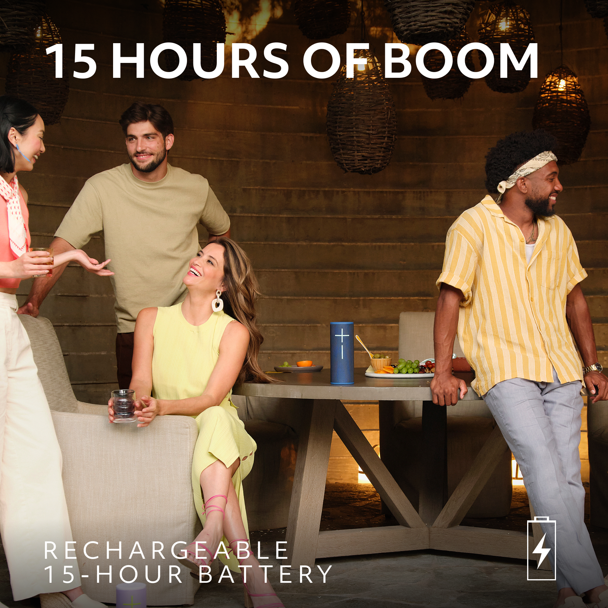 Groupe de personnes profitant d'une fête. Un haut-parleur bleu est sur la table. Le texte dit '15 HOURS OF BOOM'.