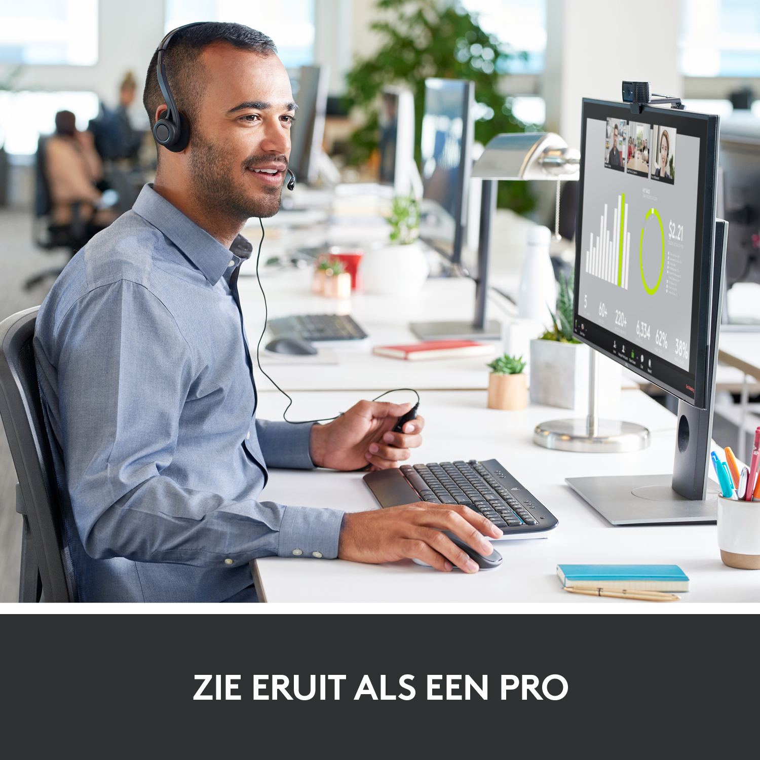 A man with a headset is on a video call in a modern office setting.