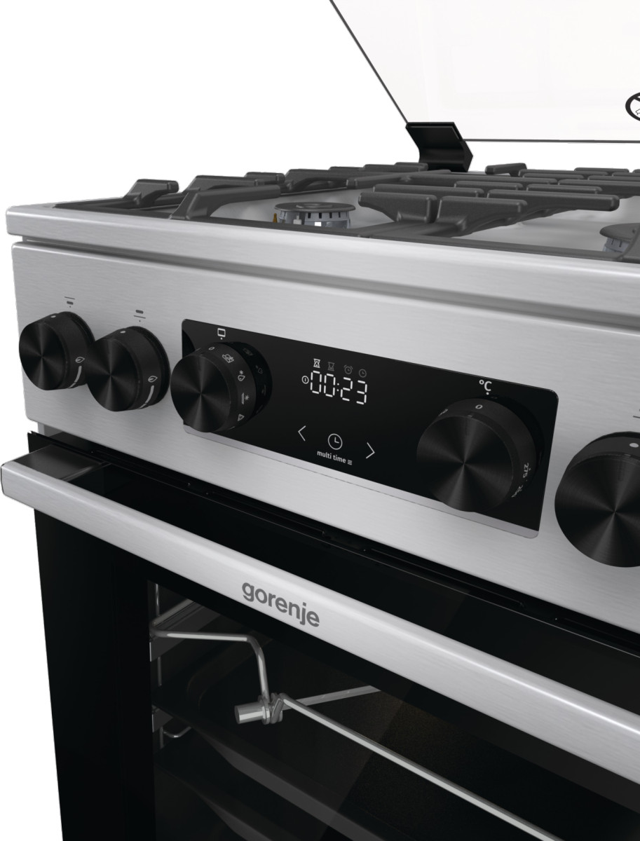 Zbliżenie panelu sterowania kuchenki, pokrętła, wyświetlacz cyfrowy z czasem.