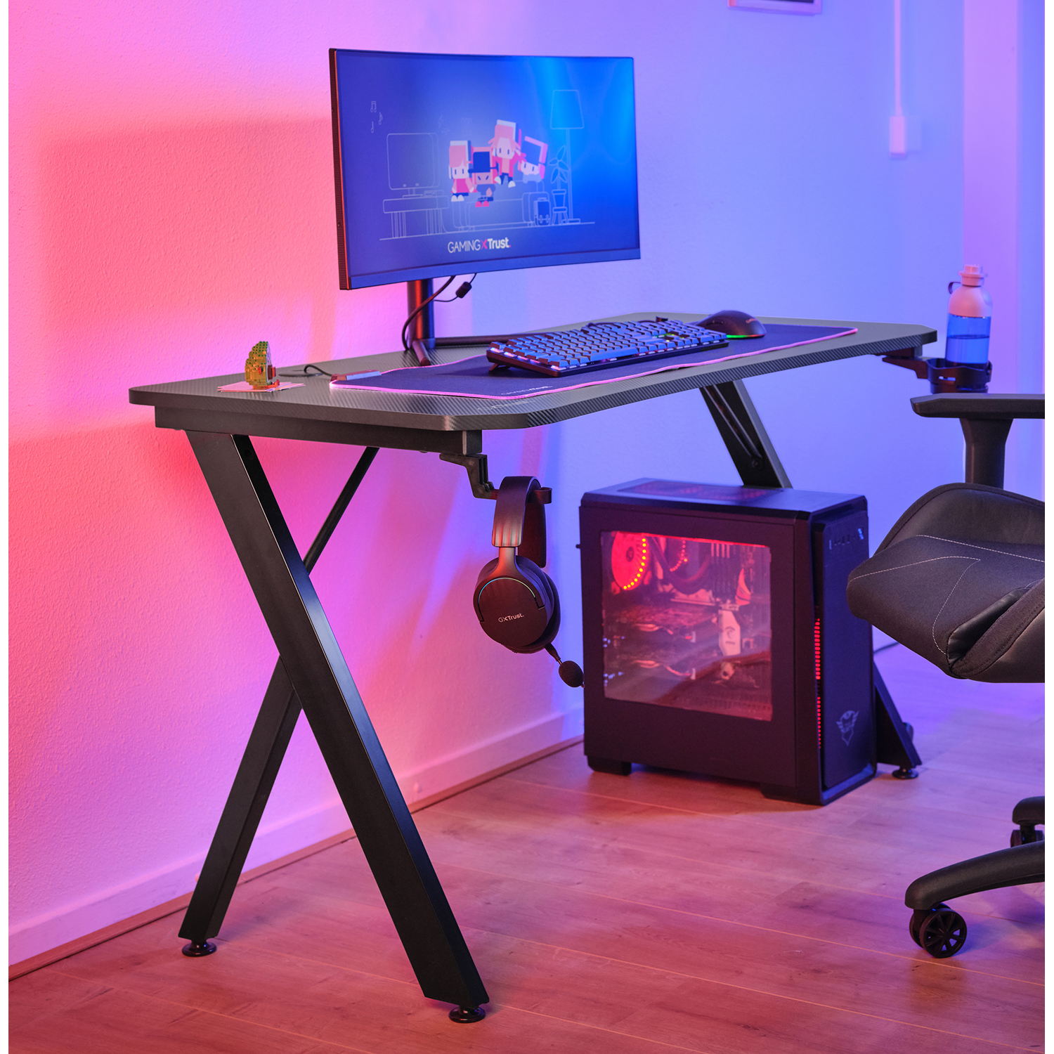 Configurazione di gioco con scrivania nera, monitor, tastiera, mouse e PC.