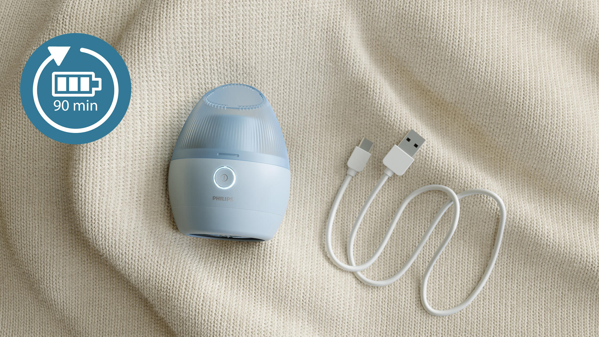 Dispositivo Philips celeste, cable USB, sobre superficie beige texturizada. Un icono de batería indica 90 min.