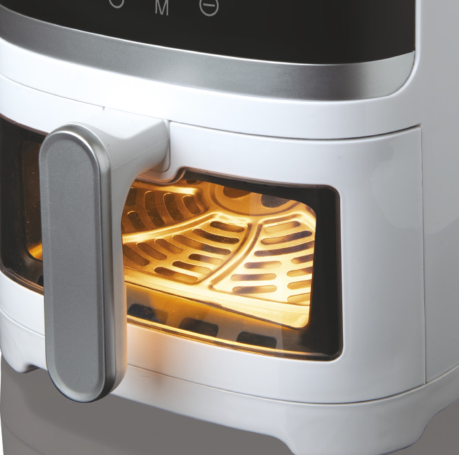 White air fryer with a handle, a window, and a glowing interior.