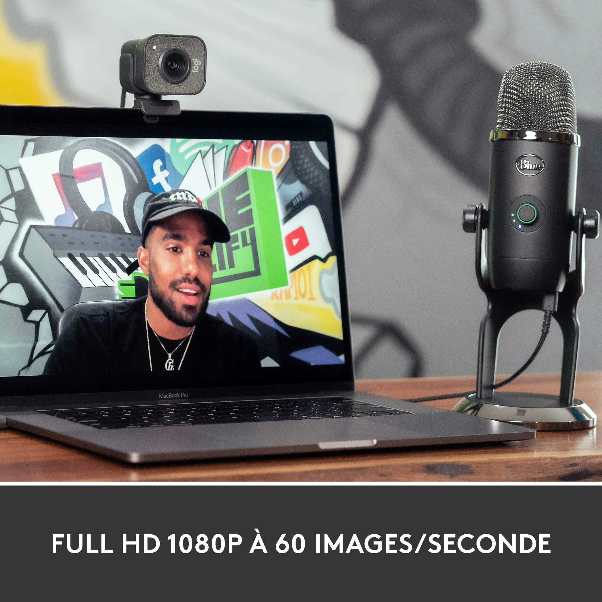 Webcam et micro sur un bureau, avec un ordinateur affichant un homme.