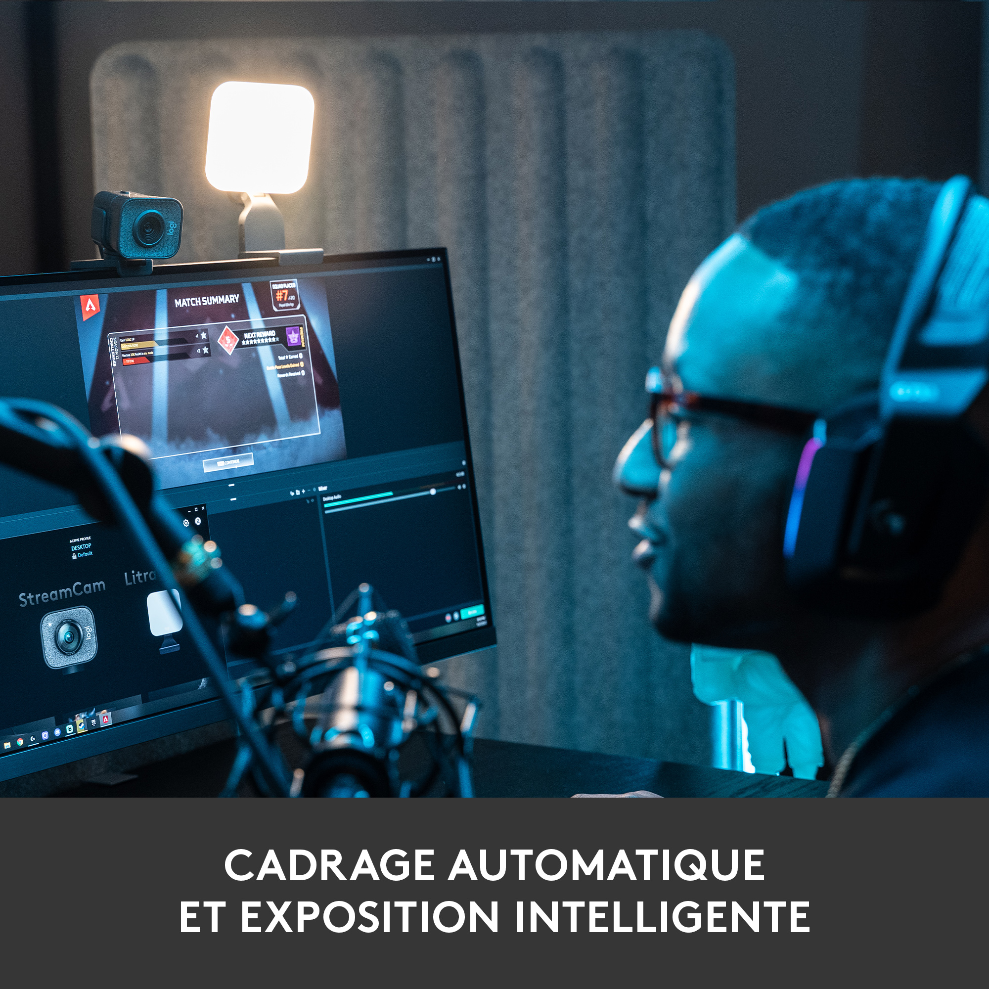 Un homme avec des lunettes et un casque devant un moniteur.
