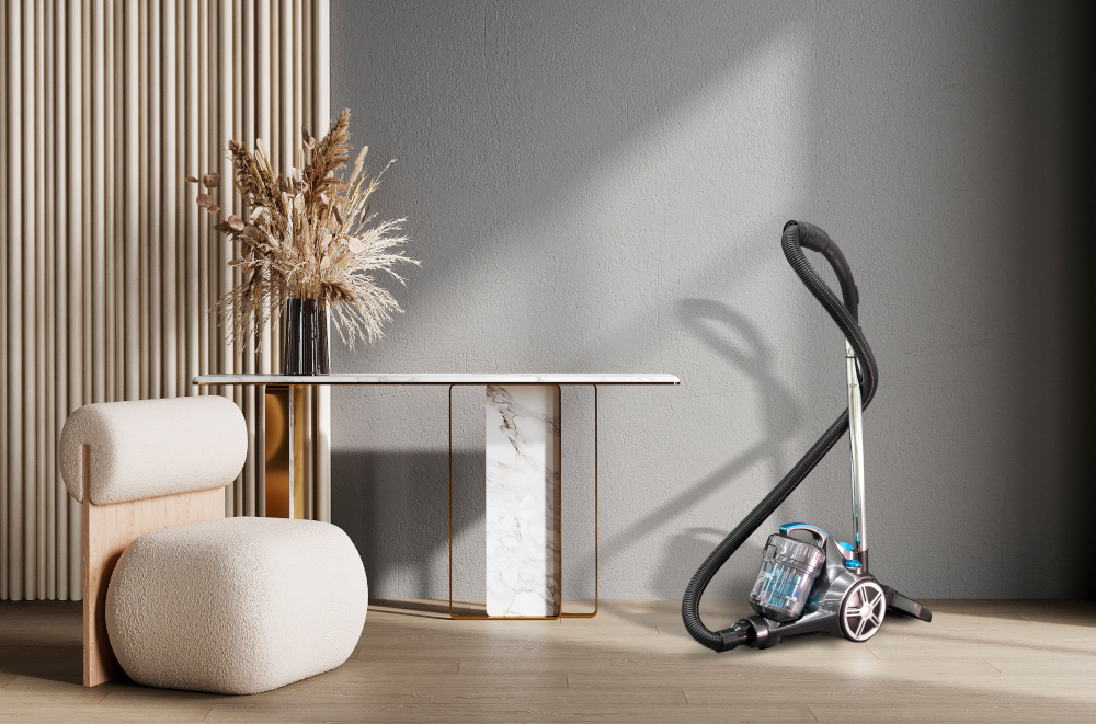 A vacuum cleaner next to a table and chair in a bright room.