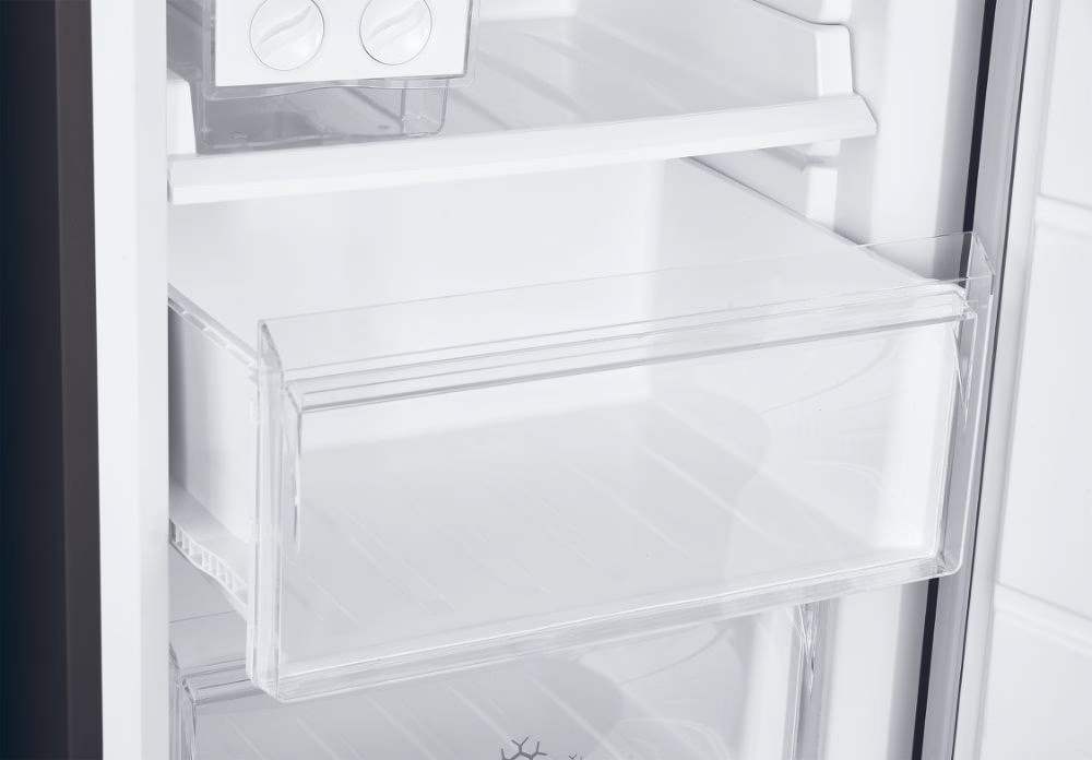 Cassetto del frigorifero, plastica trasparente. Interno bianco del frigorifero visibile.