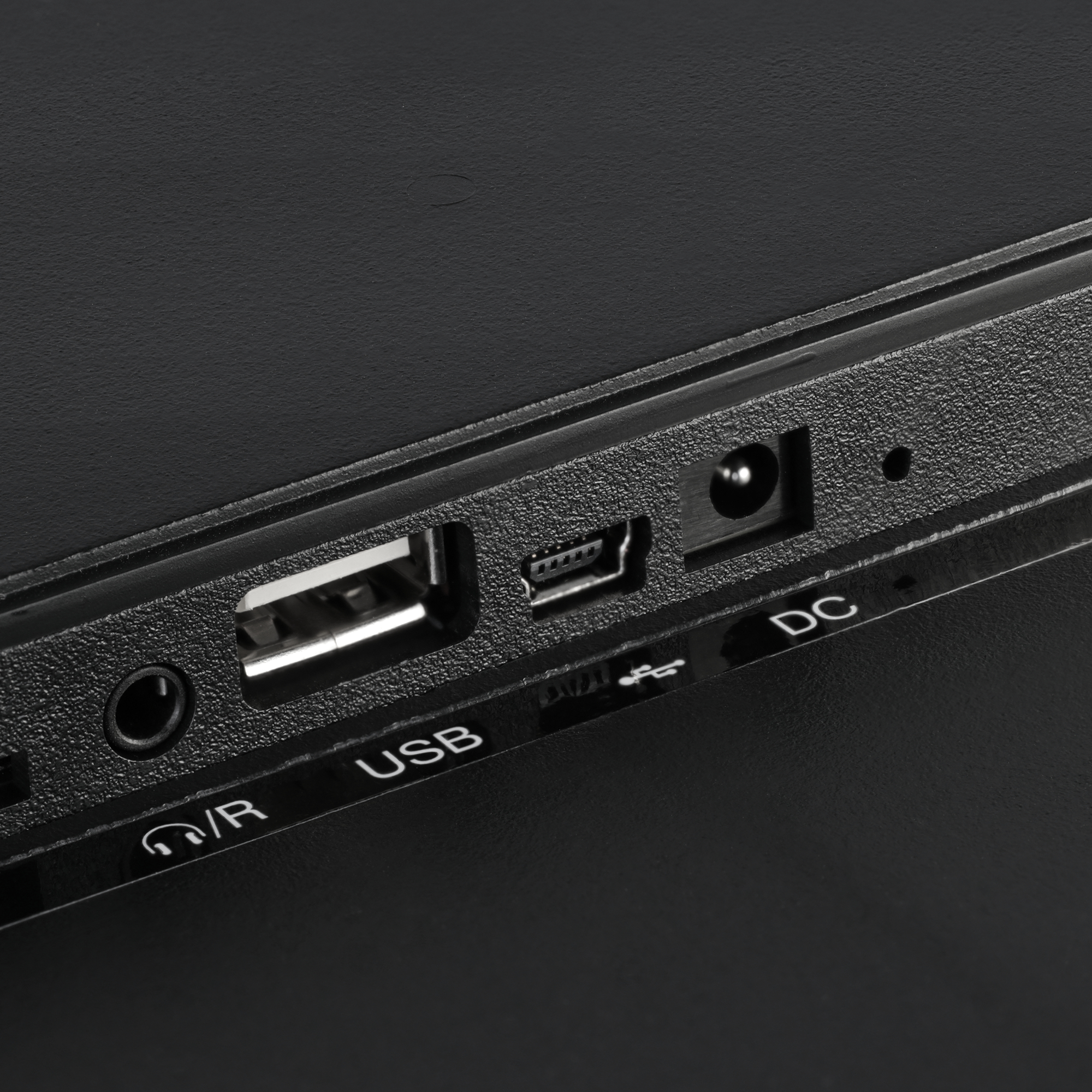 Anschlüsse an einem schwarzen Gerät: Kopfhöreranschluss, USB, Mini-USB und Gleichstrom.