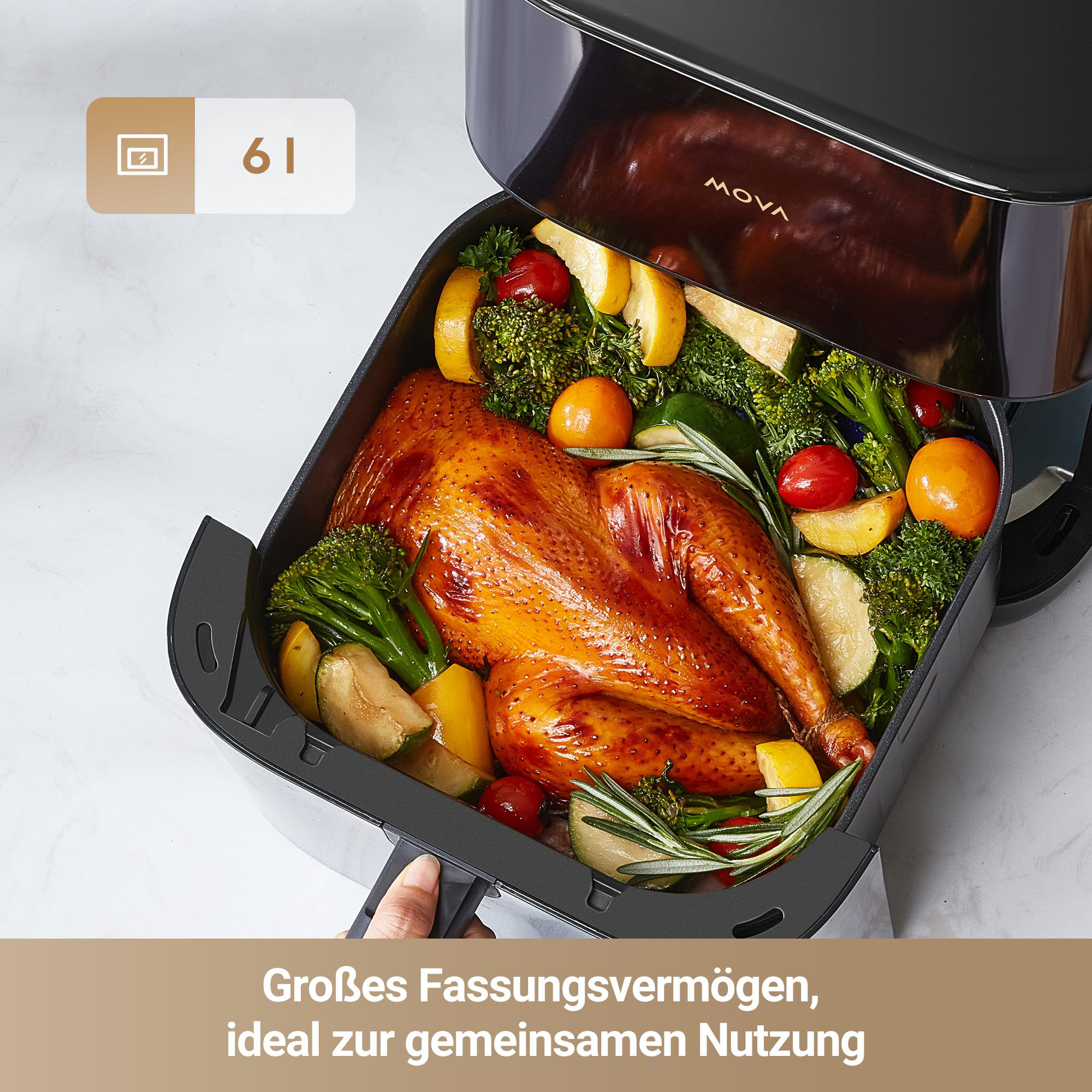 Geöffnete Heißluftfritteuse mit einem ganzen Brathähnchen und Gemüse. Die Friteuse ist schwarz und silber.