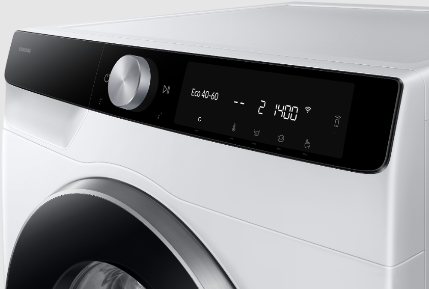 Zbliżenie białego panelu sterowania pralki z pokrętłem i wyświetlaczem cyfrowym.