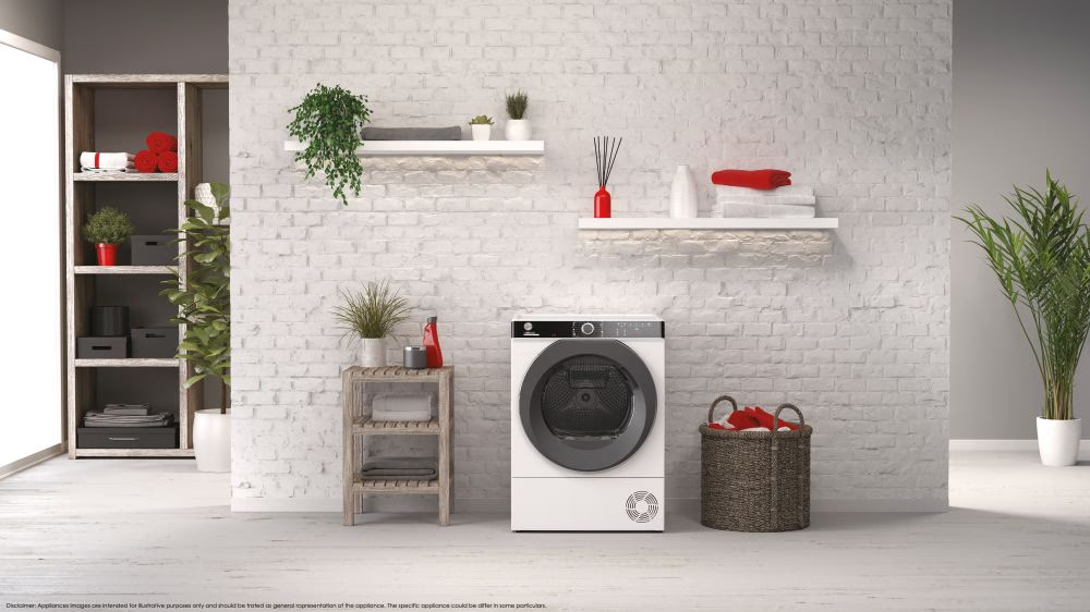 Un sèche-linge blanc, entouré de plantes et d'étagères, avec un panier et une décoration rouge.
