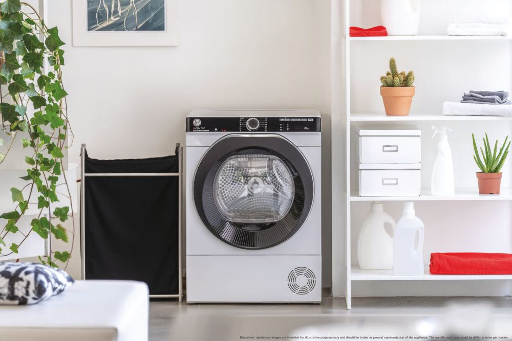 Un sèche-linge blanc avec une porte noire dans une buanderie lumineuse.