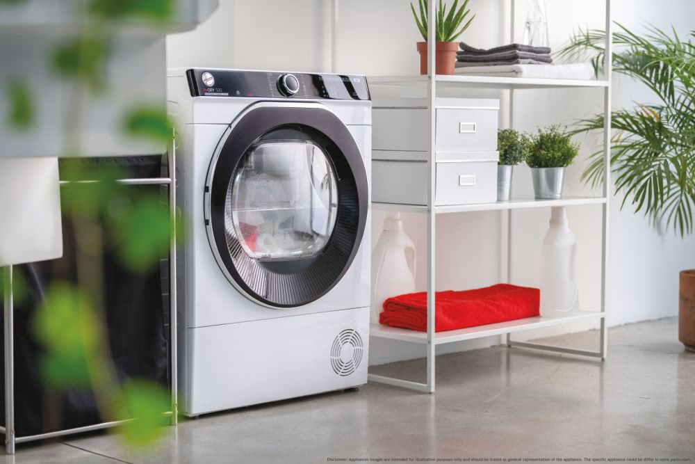 Un sèche-linge blanc est dans une pièce avec une étagère et une serviette rouge.