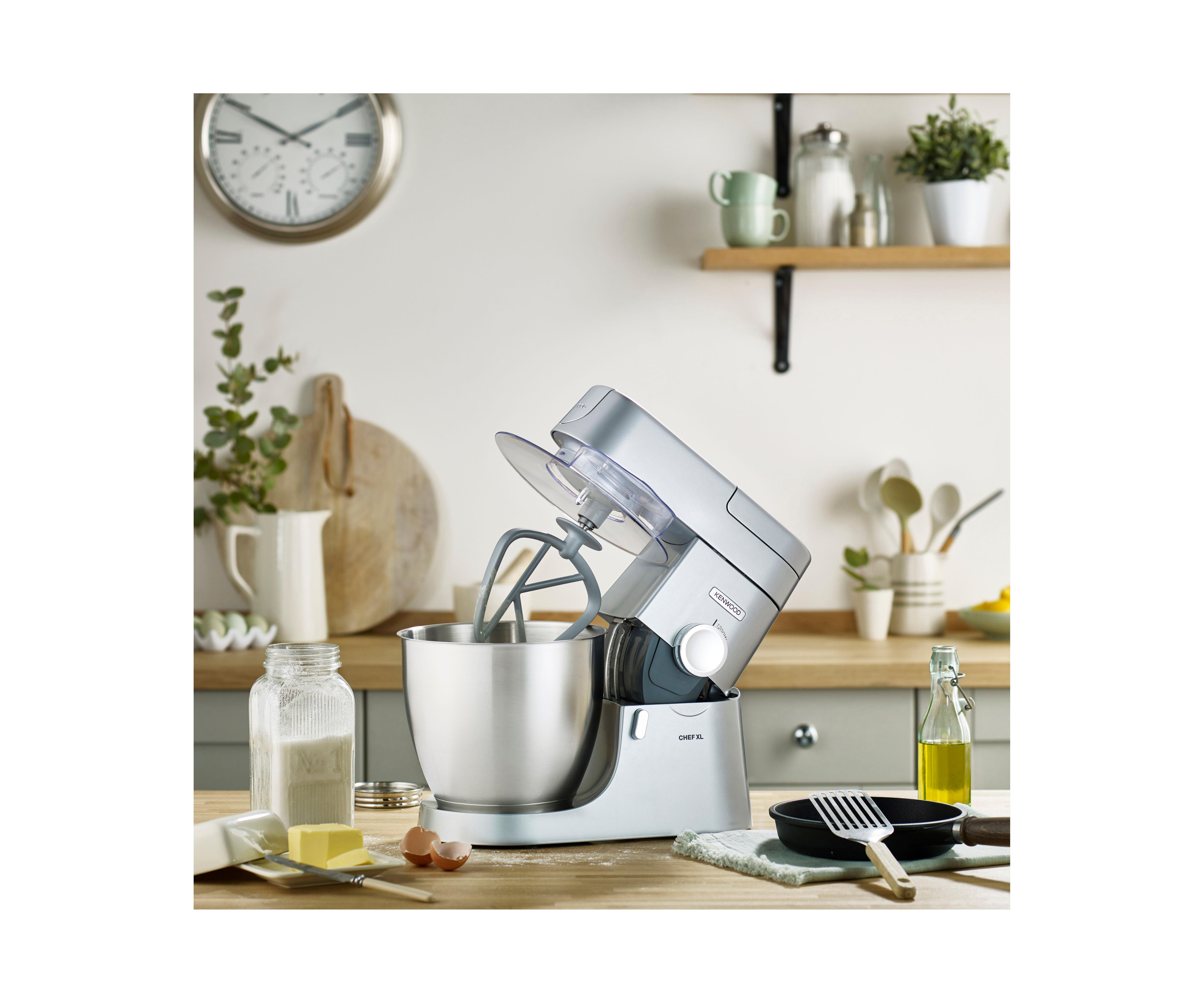 Eine Küche mit silbernem Standmixer und verschiedenen Kochutensilien.