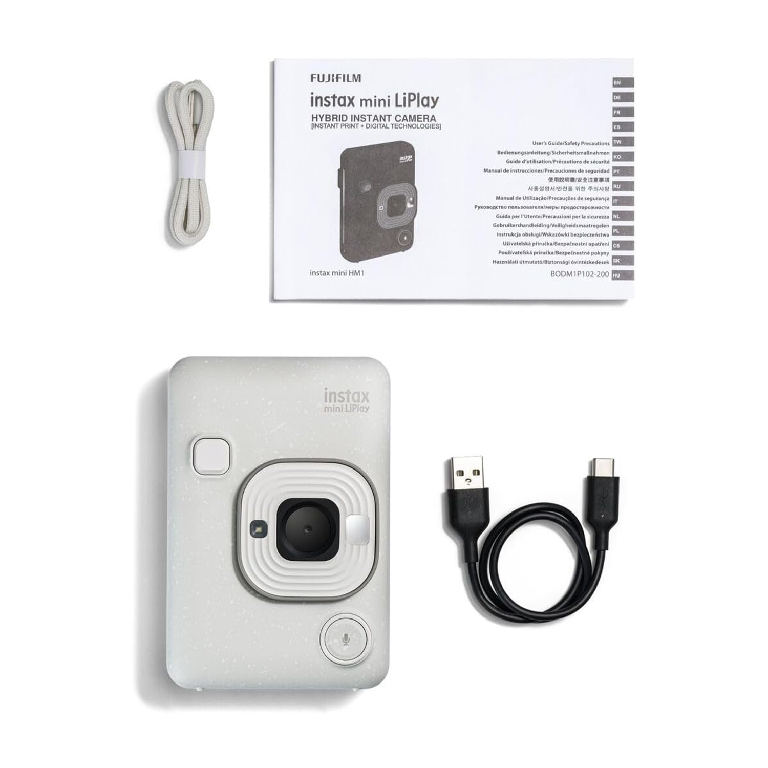 Fotocamera Instax Mini LiPlay, accessori e manuale su superficie bianca, vista dall'alto.