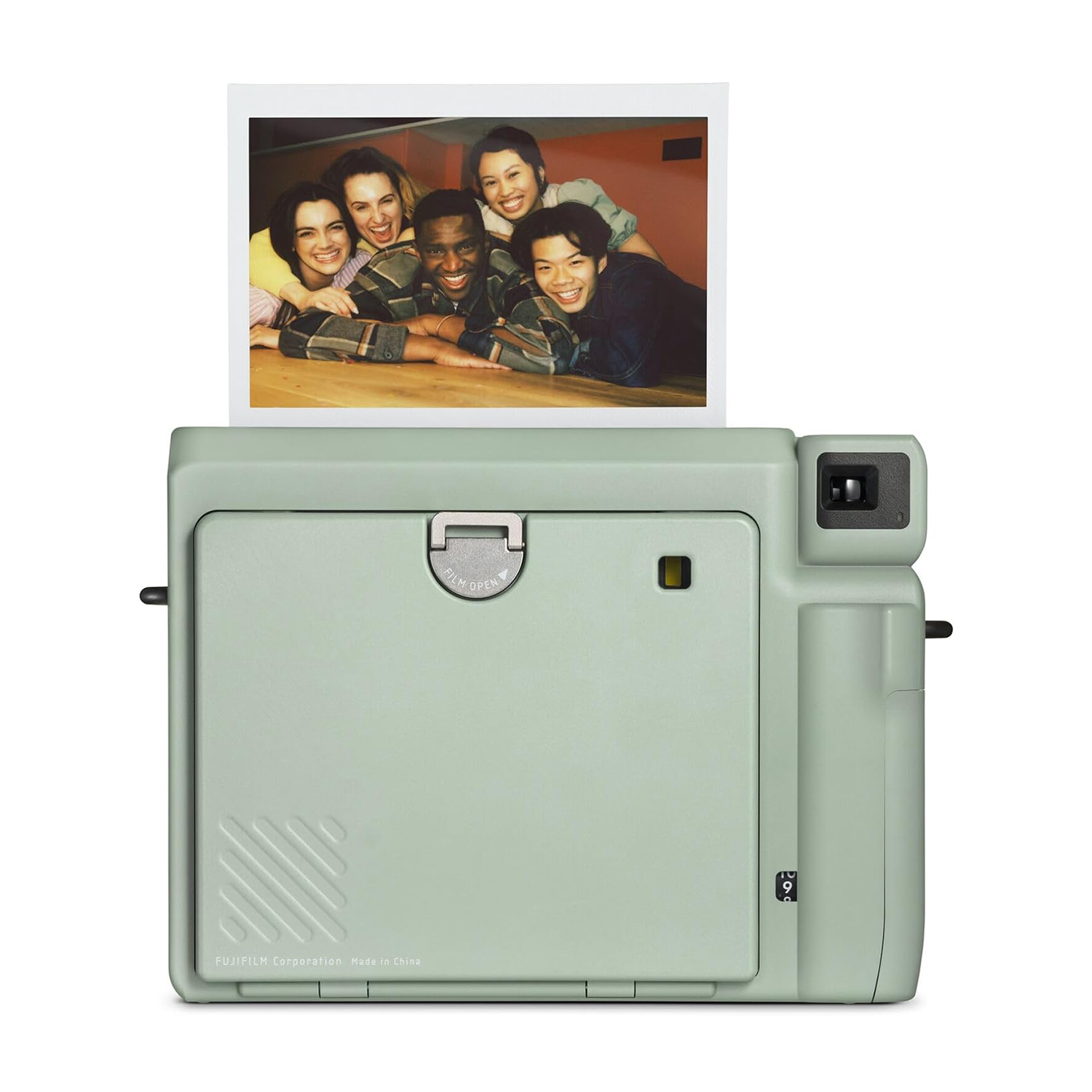 Fotocamera istantanea verde con foto di persone su sfondo bianco.