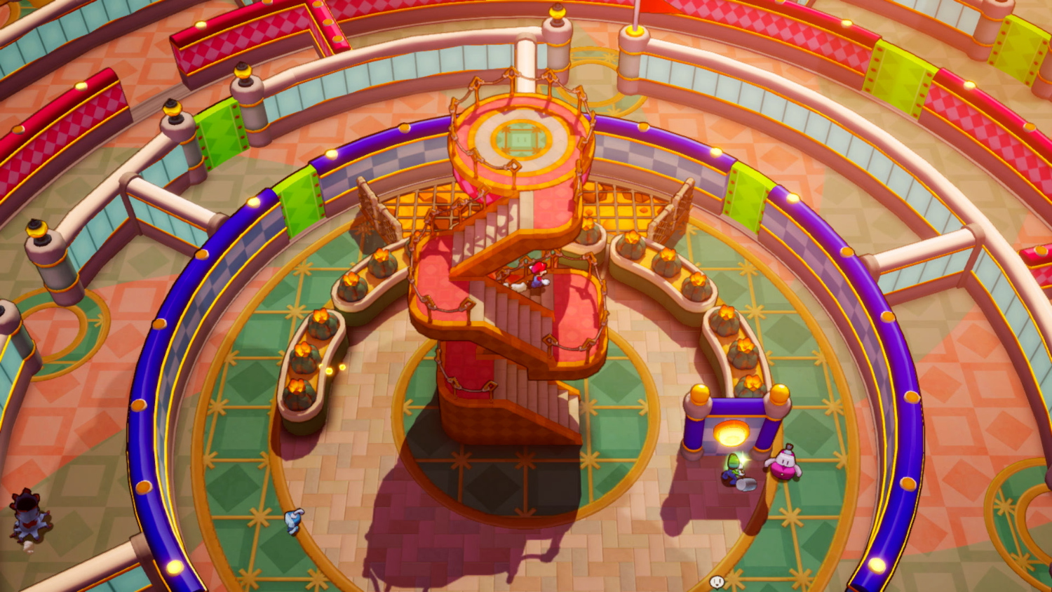 Overhead view of a colorful multi-level maze-like structure. A central spiral staircase stands prominent. 