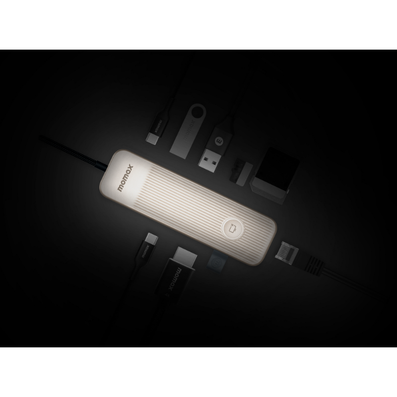 Kablolar ve diğer elektronik cihazlarla çevrili, ışıklı bir Momox cihazı.