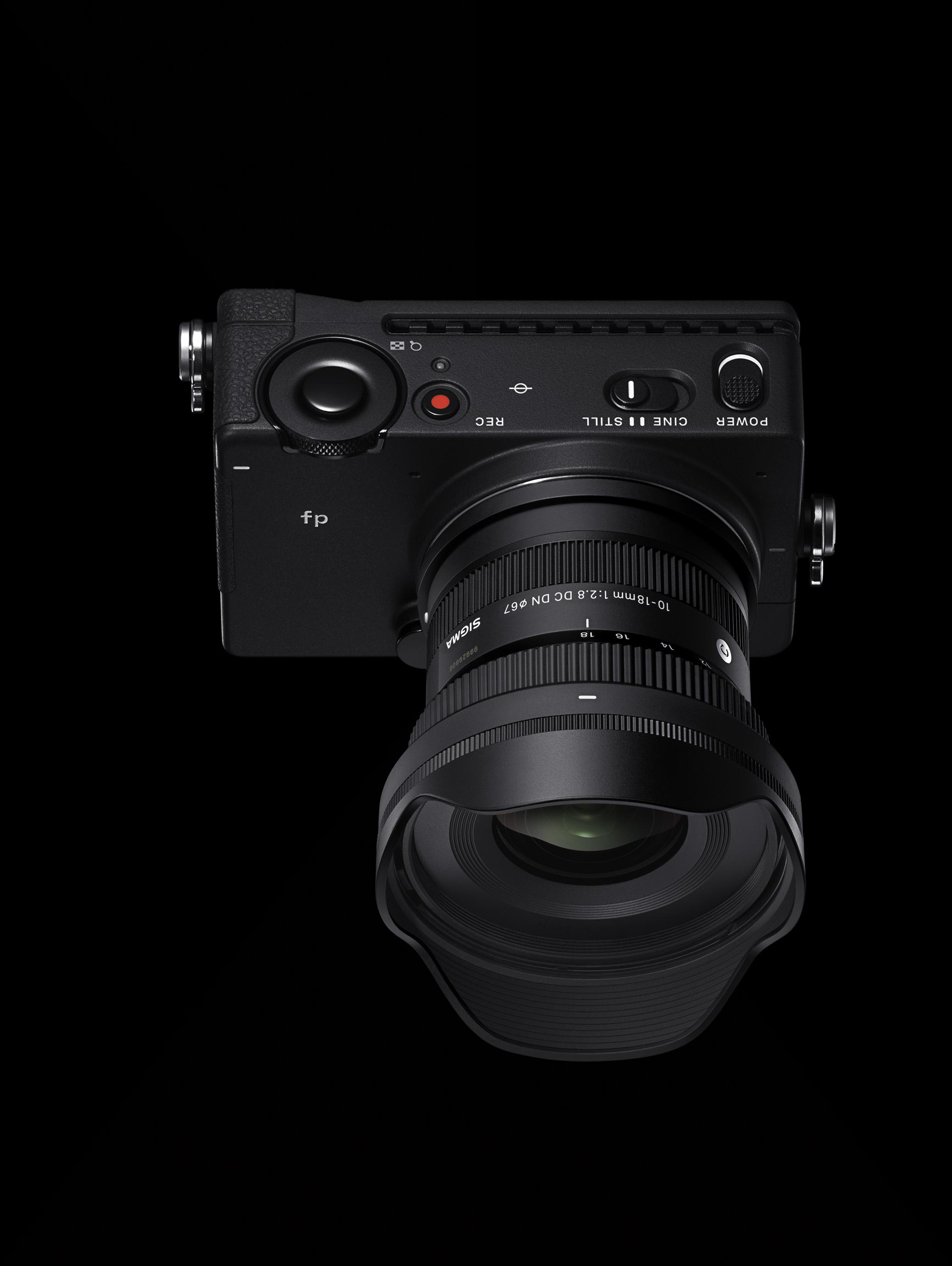 Schwarze Kamera mit Objektiv auf schwarzem Hintergrund.