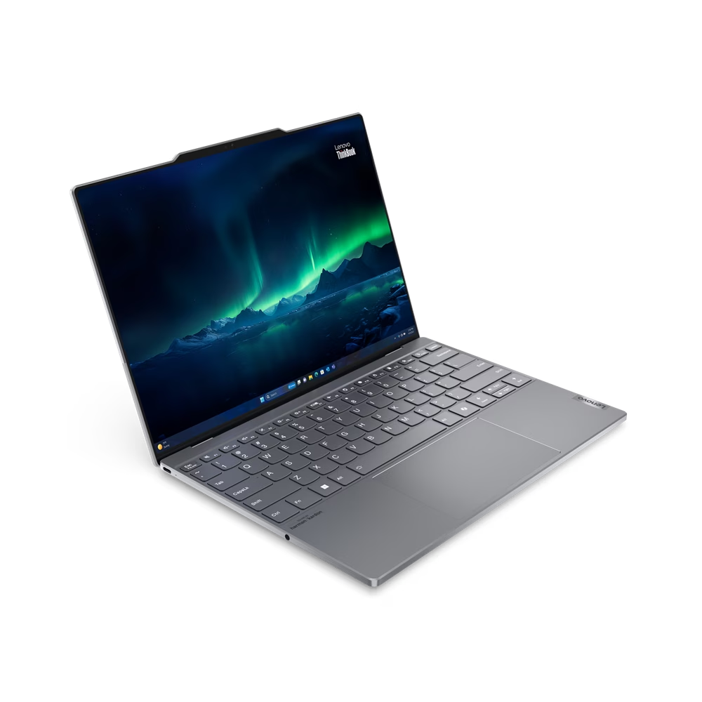 Una computadora portátil plateada con una pantalla que muestra una escena de aurora boreal sobre un fondo negro.