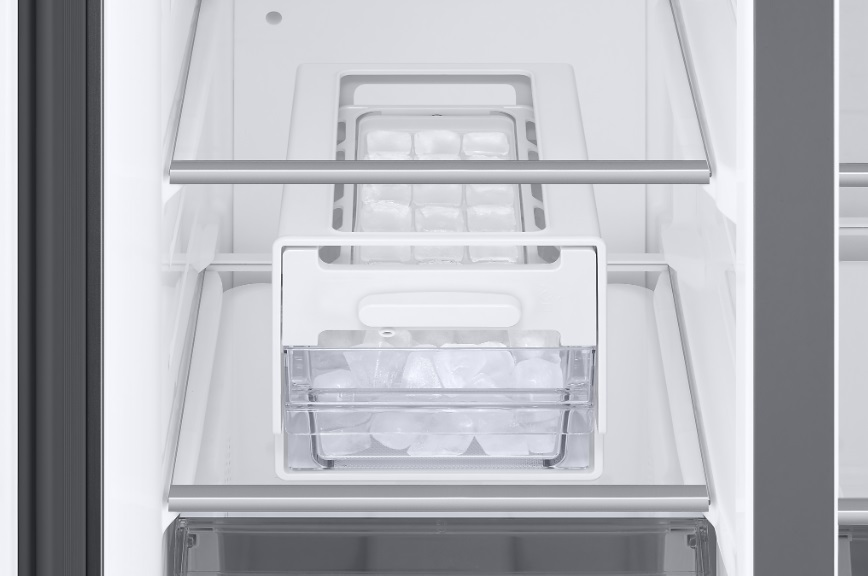 Wnętrze lodówki z kostkarką i kostkami lodu.