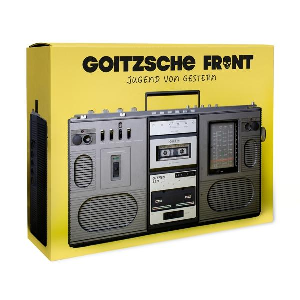 Eine Boombox in einer gelben Box. Es hat Kassettendecks und ein Radio-Display.