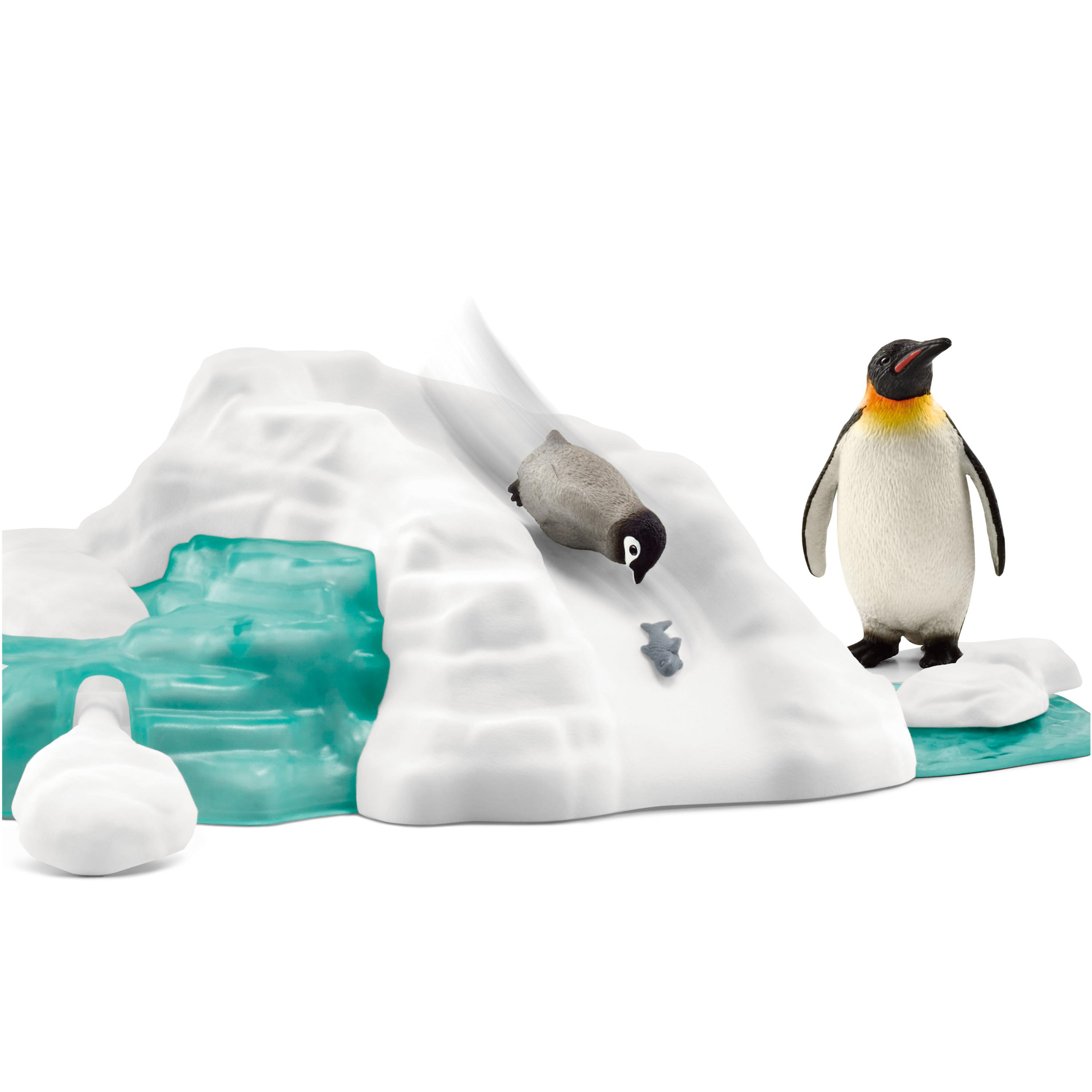 Pinguine und ein Fischspielzeug auf einer Eisstruktur, ein Pinguin steht.