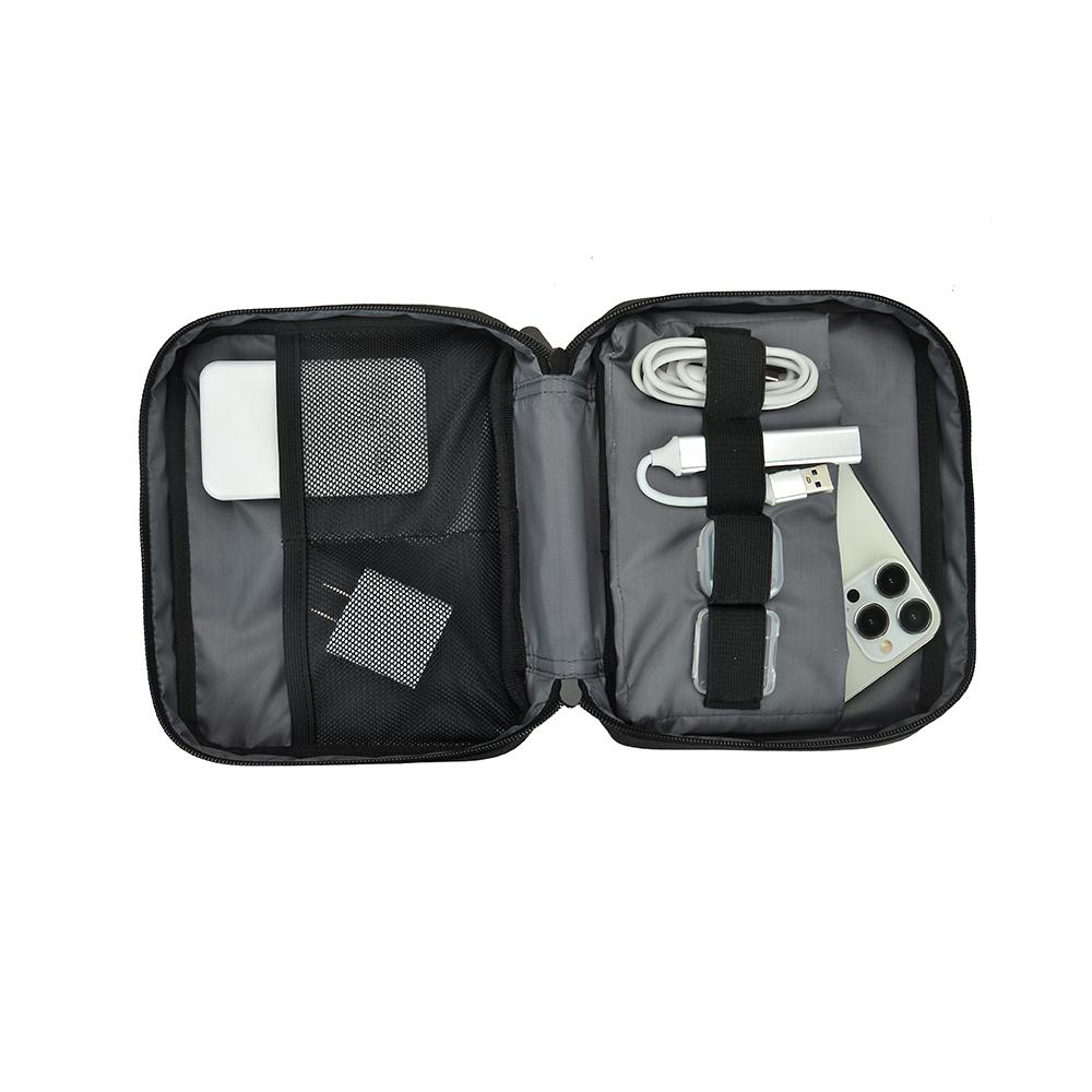 Offene schwarze Reisetasche mit Zubehör. Enthält Ladegerät, Adapter und Telefon.