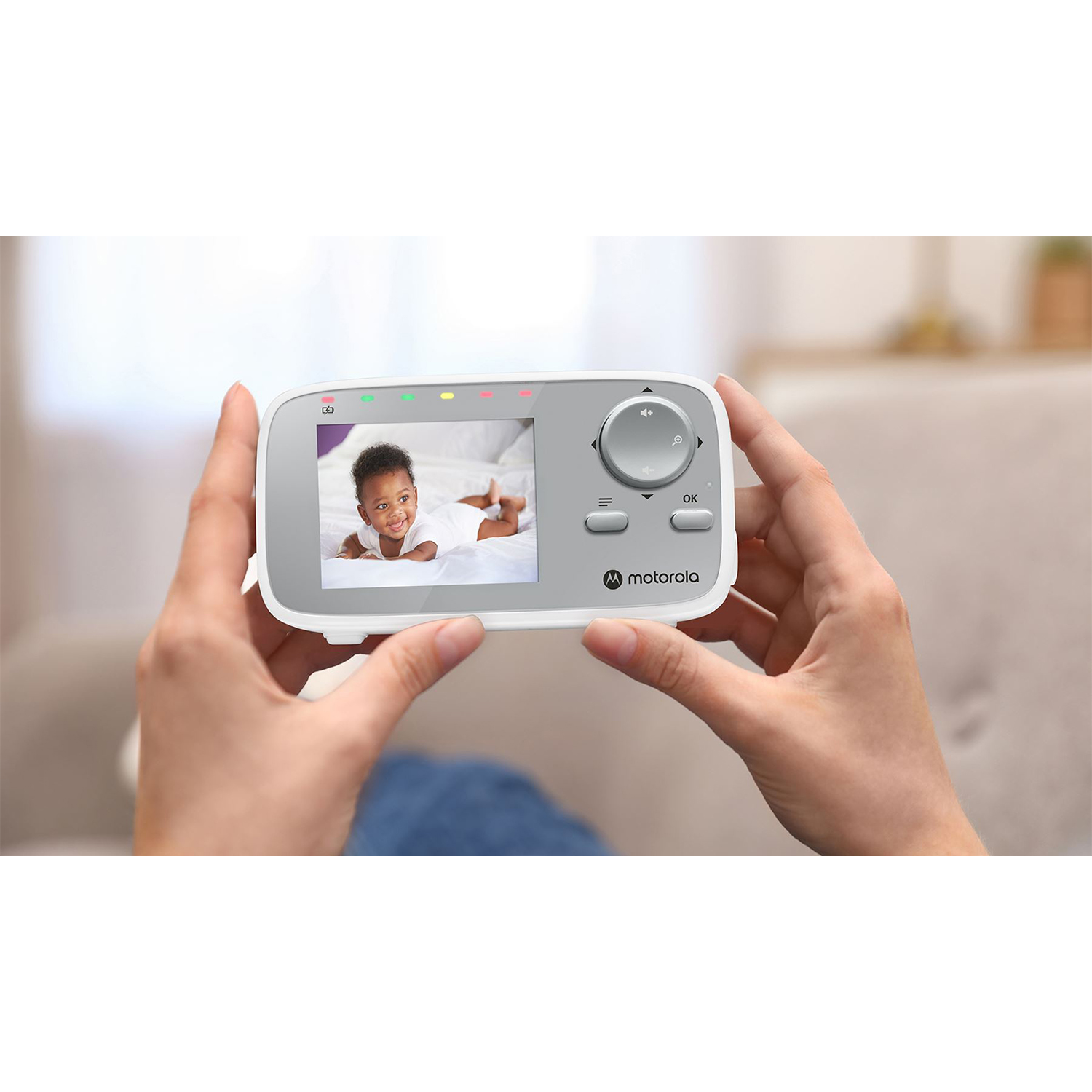 Un baby monitor che mostra un bambino sullo schermo. Le mani lo tengono.