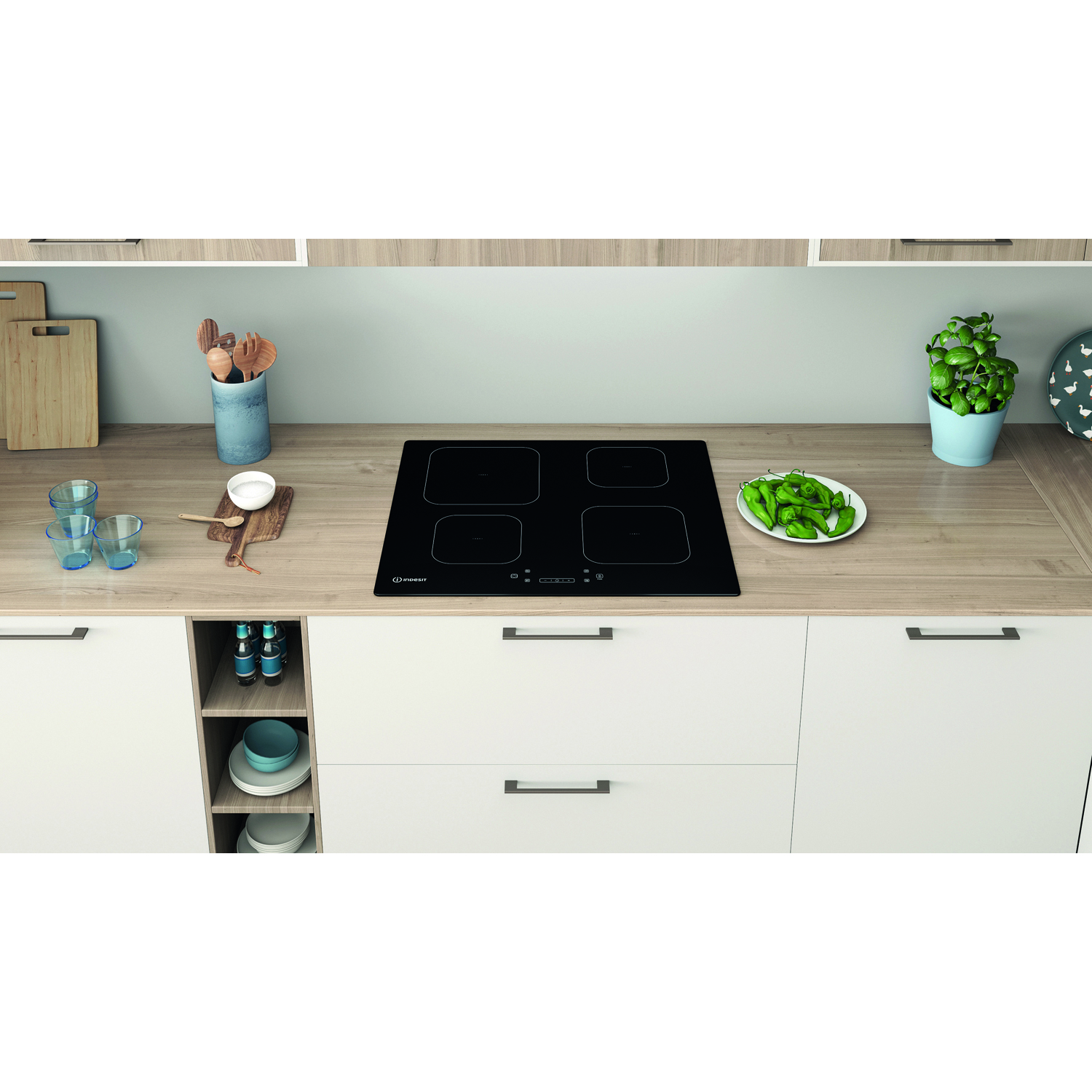 Un moderno piano cucina con piano cottura a induzione nero, armadietti ed elementi decorativi.