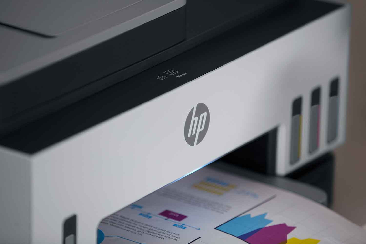 An HP printer sits on a mint green cabinet, surrounded by plants.
