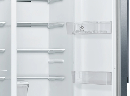 Interior de frigorífico con estantes. Estantes vacíos y un cajón transparente parcialmente visible.