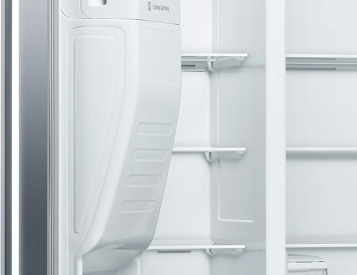 Un refrigerador blanco abierto con estantes vacíos.