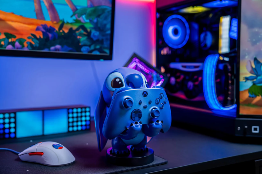 Figurine Stitch tenant une manette bleue, configuration de jeu, éclairage bleu et violet.