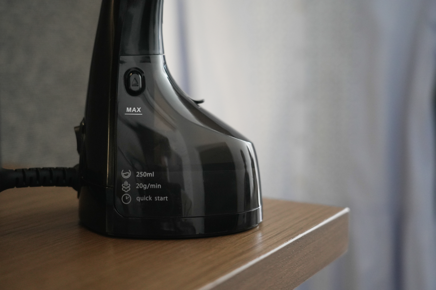 Vaporizador negro sobre una superficie de madera, con texto que indica capacidad de agua.