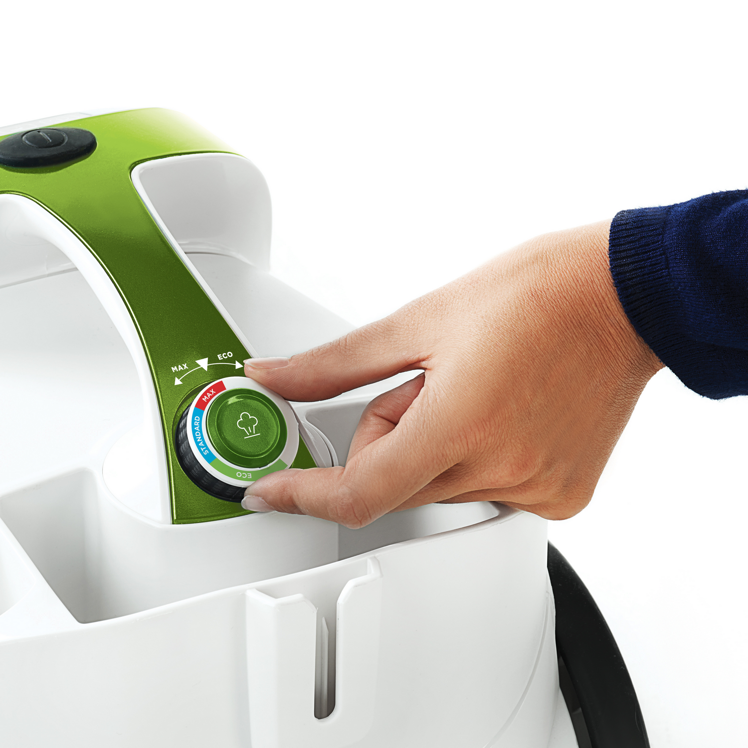 Mano de una persona ajustando un dial de electrodoméstico verde y blanco con configuraciones 'MAX', 'ECO' y 'STANDARD'.